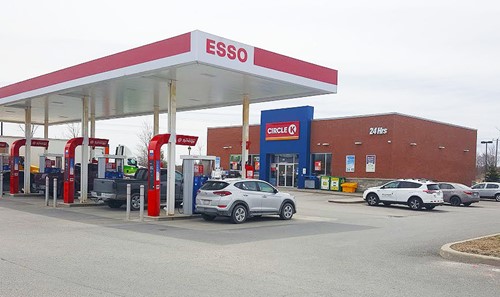 Shows exterior of Esso gas station and Circle K building behind it