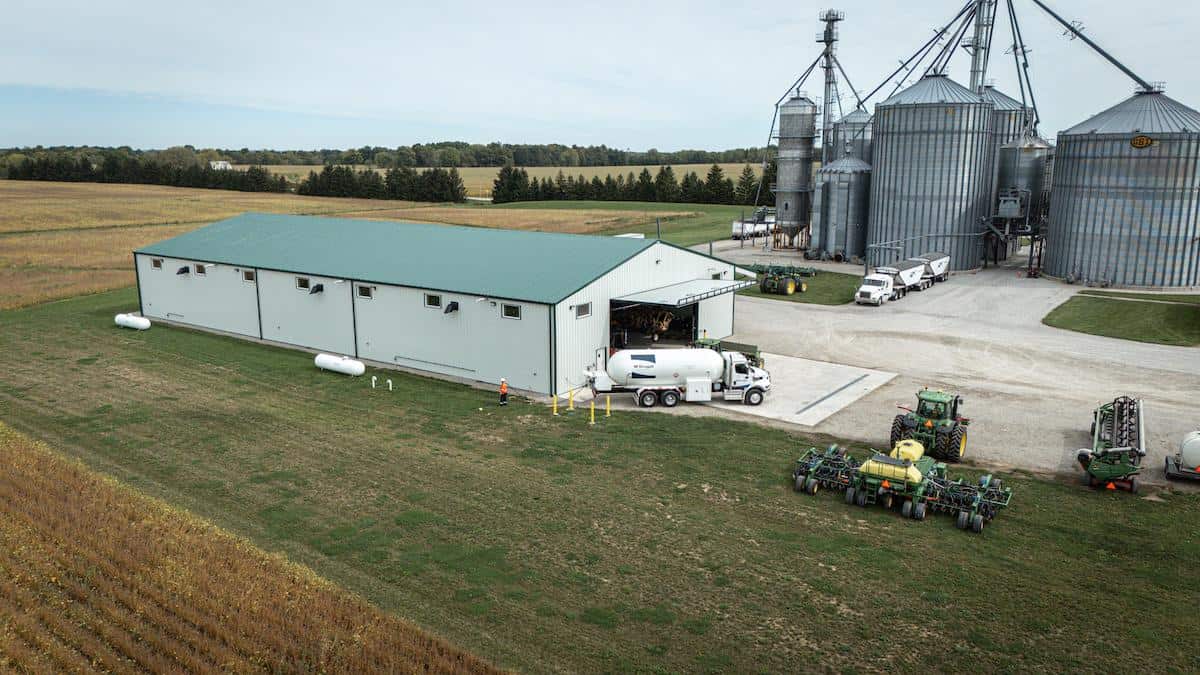 Propane storage tanks and agricultural silos at a rural fuel and energy facility.