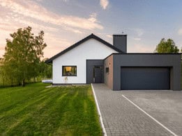 front facing modern home showing the attached garage with a propane tank for heating outside in the backyard
