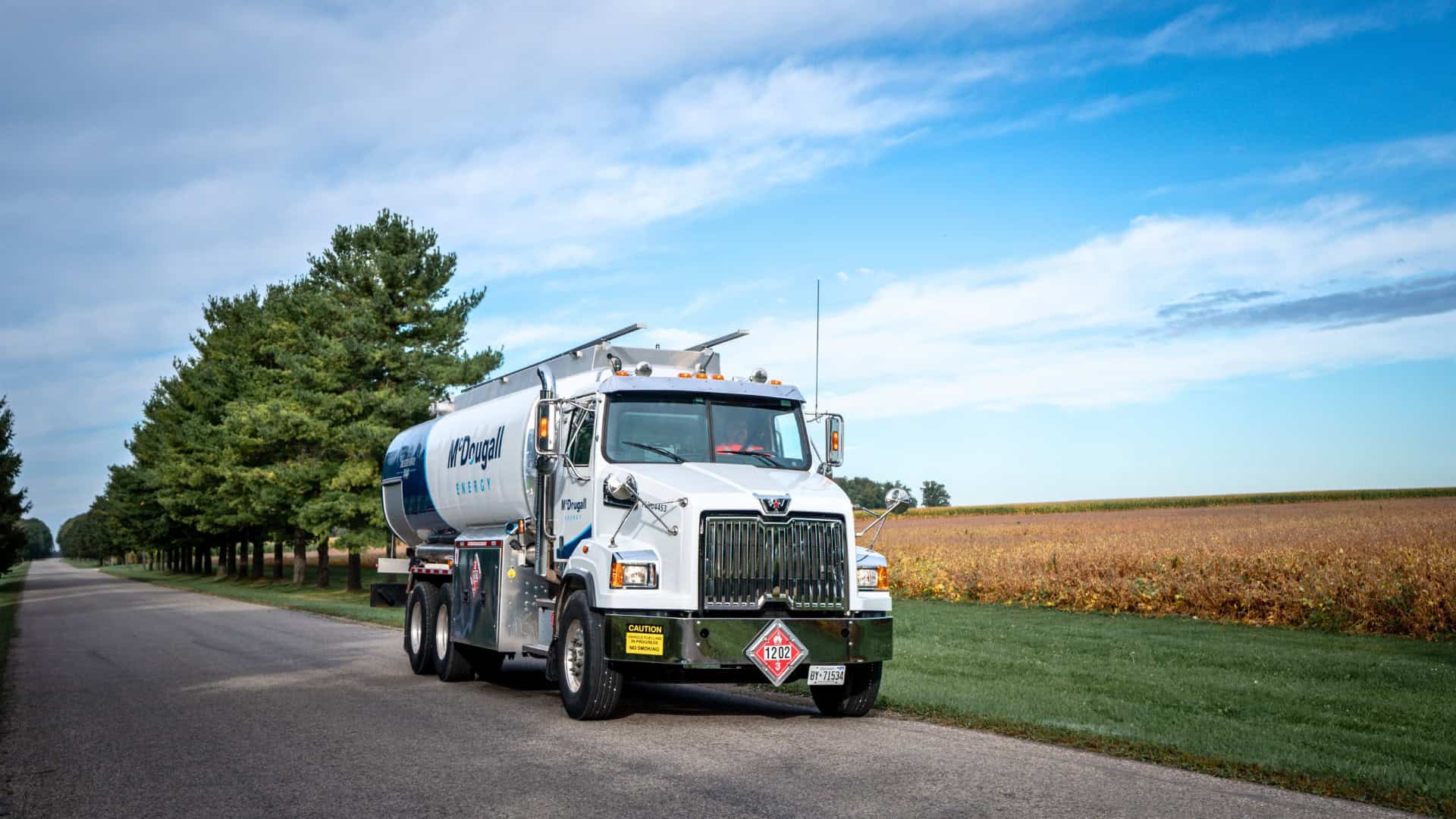 McDougall Energy fuel delivery truck on rural road in Ontario with trees and open fields in the background.