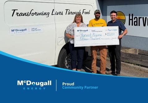 Three people holding a large cheque for 15,000 dollars