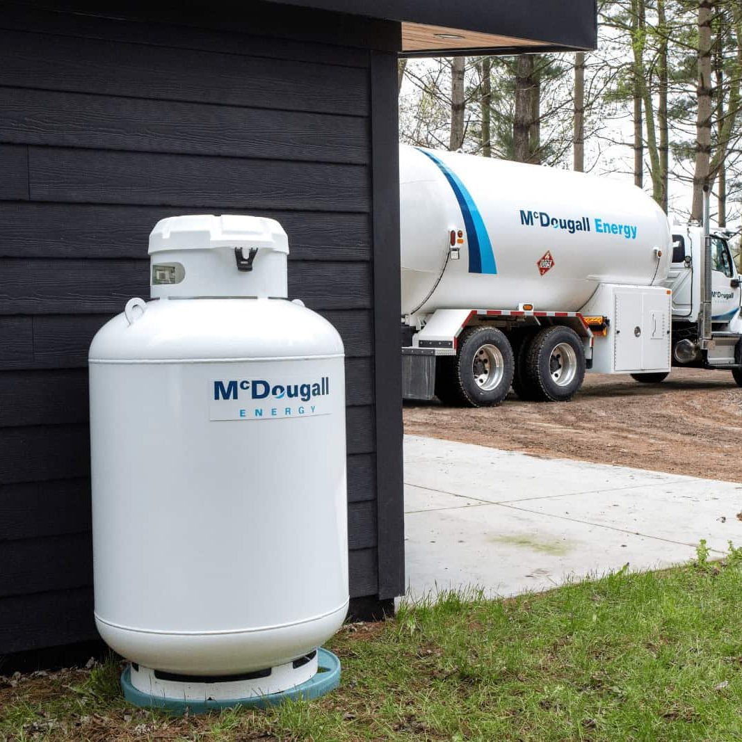 Modern propane tank near a residential property highlighting the new equipment available through the heating oil to propane conversion incentive.