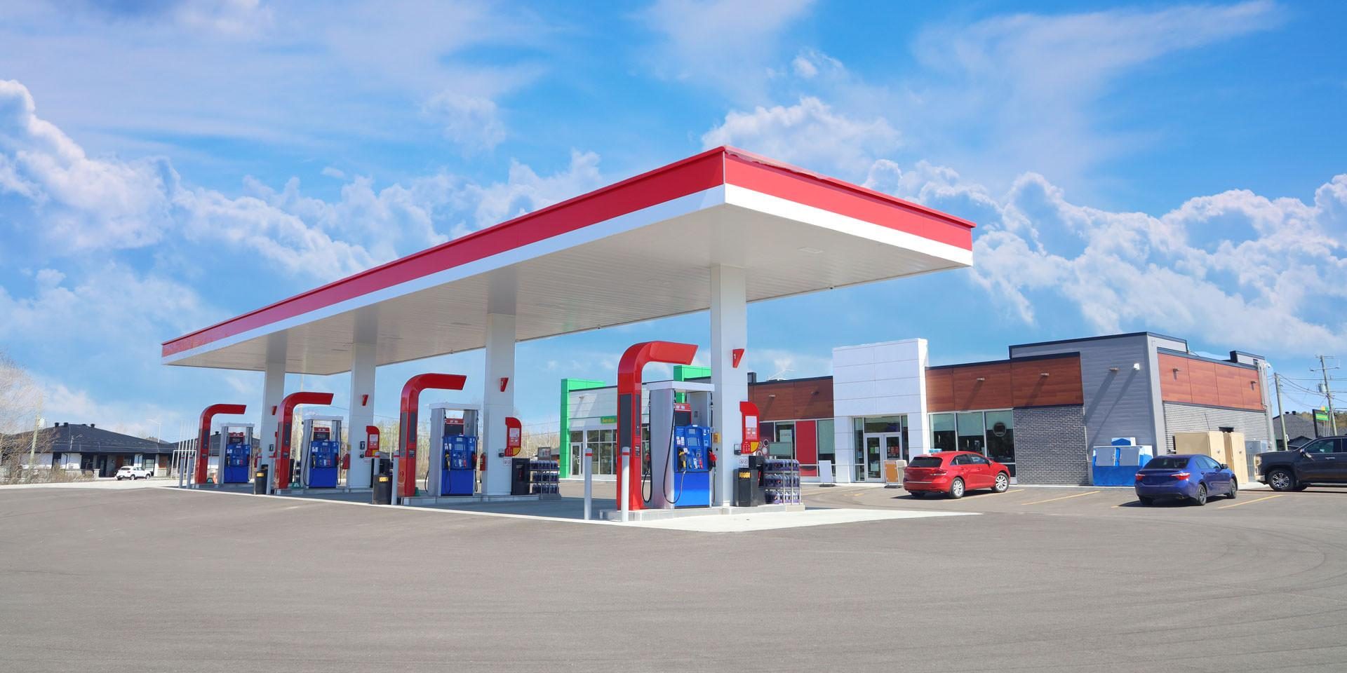 Modern Service Station with convenience store and a few cars, in a Sunny Day
