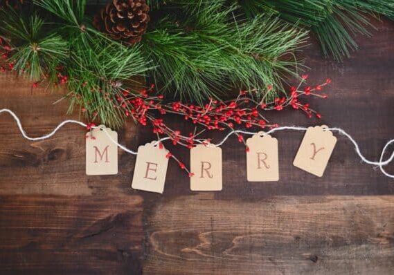 MERRY text cutout on white string by wreath