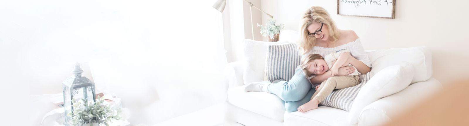 Warm family enjoying quality time on cozy white sofa at home, relaxing with loved ones.