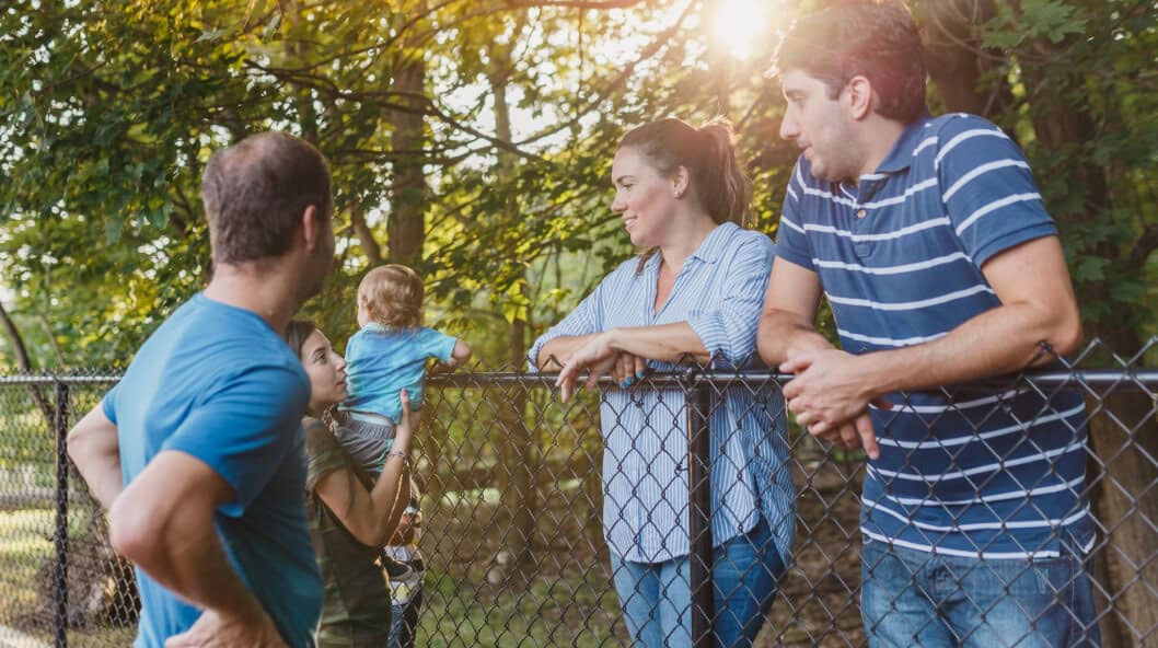 Family enjoying outdoor time in a park with sunlight filtering through trees.